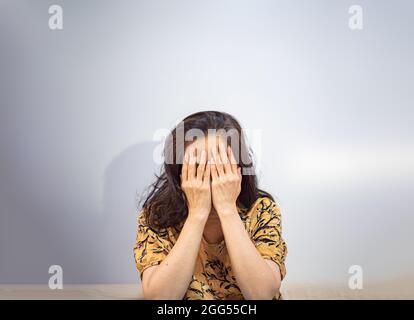 Asiatische Frau bedeckt ihr Gesicht, traurig und weinend Stockfoto