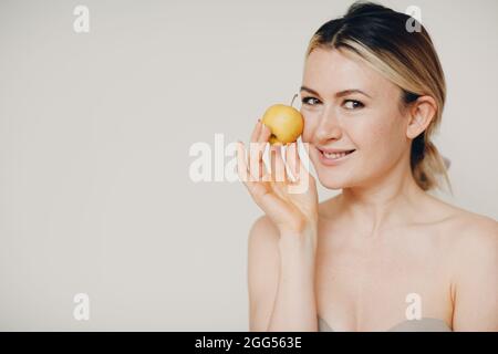 Junge schöne Frau mit Apfel in der Nähe Gesicht, Haut natürliche Pflege Kosmetik-Konzept Stockfoto