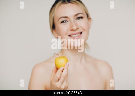 Junge schöne Frau mit Apfel in der Nähe Gesicht, Haut natürliche Pflege Kosmetik-Konzept Stockfoto