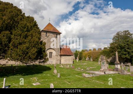 Die Kirche St. Mary aus dem 12. Jahrhundert, im äußeren bailey von Portchester Castle: Friedhof und nahe gelegene Mauern des ursprünglichen römischen Forts, Hampshire, Großbritannien Stockfoto