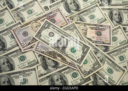 Ein Geldstapel verschiedener US-Banknoten mit einem Porträt des Präsidenten Washington oben. Bargeld in Dollar, Hintergrund der Papierwährung. Stockfoto