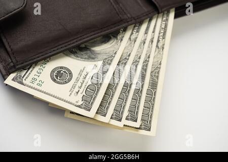 Ledergeldbörse voller Geld auf weißem Hintergrund - Fan von hundert US-Banknoten mit Präsident Franklin-Porträt. Bargeld von hundert Dollarscheinen, pap Stockfoto