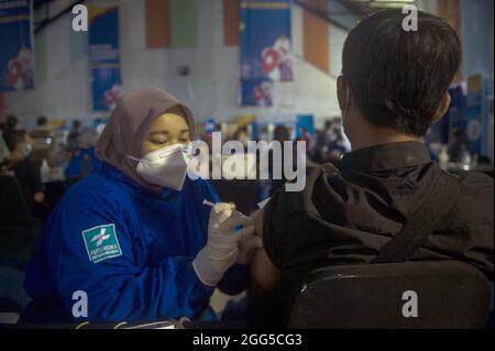 Mitglieder der mobilen Anwendung „Indonesian Health Halodoc“ erhielten am 28. August 2021 die Massenimpfung von Covid-19 durch das Joint Impfzentrum der SOEs auf dem Andromeda-Flugplatz Soewondo, Medan, Indonesien. Durch die digital-basierte Registrierung der Healthy Living Community Movement (Germas). Indonesien führt aggressiv Massenimpfungen für alle Indonesier durch, um die Corona-Virus-Pandemie zu bekämpfen. Foto von Aditya Sutanta/ABACAPRESS.COM Stockfoto