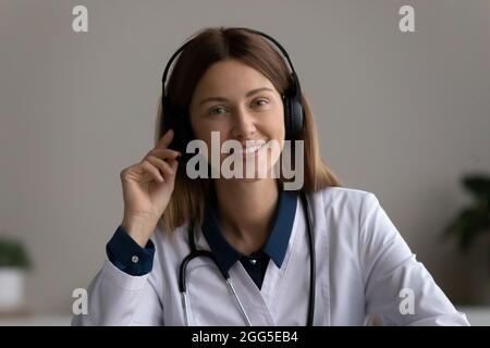 Porträt eines glücklichen, erfahrenen jungen Arztes im Headset. Stockfoto