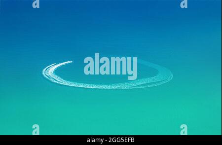 Wassersport am Strand Luftbild. Schnellboot und Wellengleiter verlassen den Rundweg auf dem Wasser Stockfoto