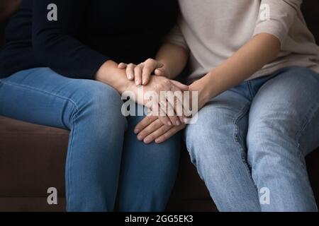 Nahaufnahme einer jungen Frau, die die Hände einer älteren Mutter bedeckt. Stockfoto