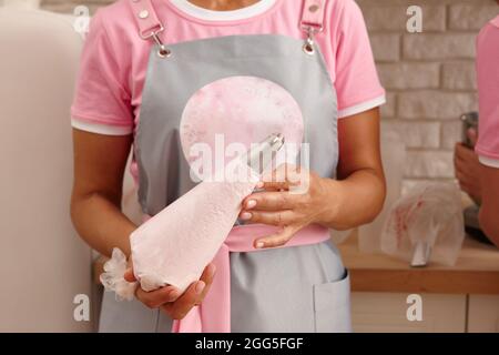 Konditor in Schürze mit Tüte, Nahaufnahme Stockfoto