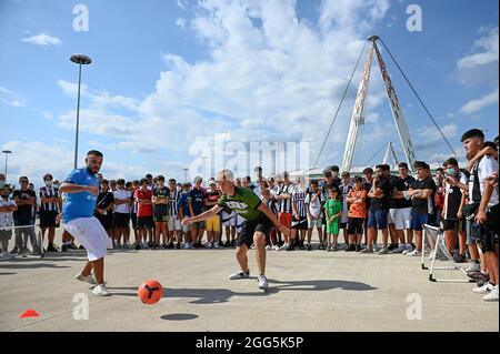 Turin, Italien. 28. August 2021. Die junge Fußballspielerin FIUs Gamer (Andrea Fusco) im SSC Napoli-Trikot spielt vor dem Allianz Stadium vor dem Fußballspiel der Serie A zwischen Juventus FC und Empoli FC ein gegen ein (1v1) Fußballspiel gegen einen jungen Juventus FC-Fan. Kredit: Nicolò Campo/Alamy Live Nachrichten Stockfoto