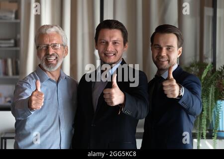 Porträt eines lächelnden, erfolgreichen Mitarbeiterteams, das Daumen nach oben zeigt Stockfoto