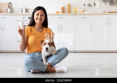 Glücklich asiatische Dame mit niedlichen doggy zeigen Haustiere Ergänzung Glas Stockfoto