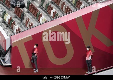 Tokio, Japan. August 2021. Paralympics: Leichtathletik, im Olympiastadion. Freiwillige stehen am Eingang des Stadions. Kredit: Marcus Brandt/dpa/Alamy Live Nachrichten Stockfoto