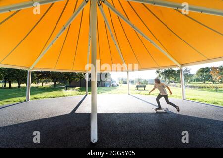 Carrigaline, Cork, Irland. August 2021. Joshua O Drisceoil skates under the Canopy of the New Bandstand at the Community Park in Carrigaline, Co. Cork, Ireland. - Credit: David Creedon / Alamy Live News Stockfoto