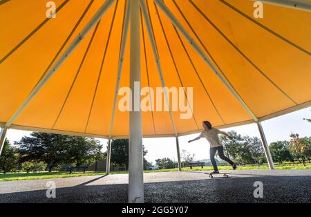 Carrigaline, Cork, Irland. August 2021. Joshua O Drisceoil skates under the Canopy of the New Bandstand at the Community Park in Carrigaline, Co. Cork, Ireland. - Credit: David Creedon / Alamy Live News Stockfoto