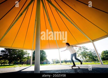 Carrigaline, Cork, Irland. August 2021. Joshua O Drisceoil skates under the Canopy of the New Bandstand at the Community Park in Carrigaline, Co. Cork, Ireland. - Credit: David Creedon / Alamy Live News Stockfoto