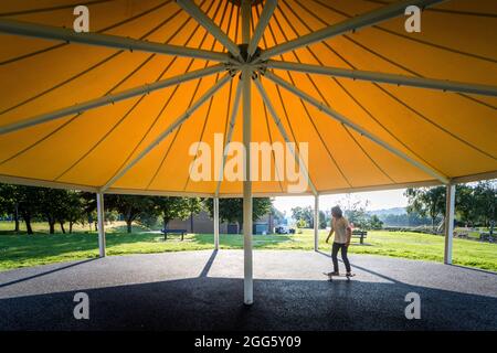 Carrigaline, Cork, Irland. August 2021. Joshua O Drisceoil skates under the Canopy of the New Bandstand at the Community Park in Carrigaline, Co. Cork, Ireland. - Credit: David Creedon / Alamy Live News Stockfoto