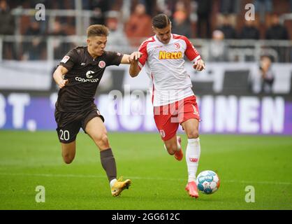 Hamburg, Deutschland. August 2021. Fußball: 2. Bundesliga, Matchday 5: FC St. Pauli - Jahn Regensburg im Millerntor-Stadion. Finn Ole Becker (l) von St. Pauli und Erik Wekesser von Regensburg kämpfen um den Ball. Quelle: Daniel Reinhardt/dpa - WICHTIGER HINWEIS: Gemäß den Bestimmungen der DFL Deutsche Fußball Liga und/oder des DFB Deutscher Fußball-Bund ist es untersagt, im Stadion und/oder vom Spiel aufgenommene Fotos in Form von Sequenzbildern und/oder videoähnlichen Fotoserien zu verwenden oder zu verwenden./dpa/Alamy Live News Stockfoto