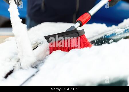 Person mit Besen, die in Nahaufnahme Schnee von der Windschutzscheibe putzt  Stockfotografie - Alamy