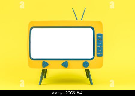 Vintage Miniatur-Spielzeug-Fernseher auf gelbem Hintergrund. Stockfoto