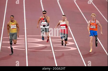 Action von den 100 m der Männer - T63 Heat 2 als der deutsche Leon Schaefer am fünften Tag der Paralympischen Spiele in Tokio 2020 in Japan bei der Leichtathletik im Olympiastadion gegen Daniel Wagner gewinnt. Bilddatum: Sonntag, 29. August 2021. Stockfoto