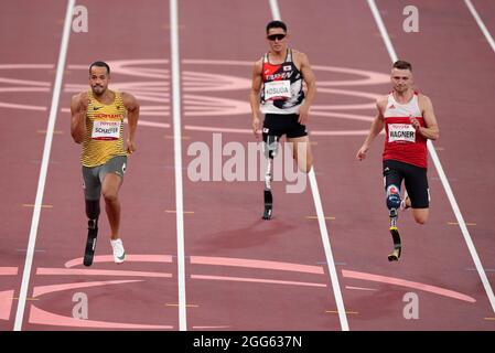 Action von den 100 m der Männer - T63 Heat 2 als der deutsche Leon Schaefer am fünften Tag der Paralympischen Spiele in Tokio 2020 in Japan bei der Leichtathletik im Olympiastadion gegen Daniel Wagner gewinnt. Bilddatum: Sonntag, 29. August 2021. Stockfoto