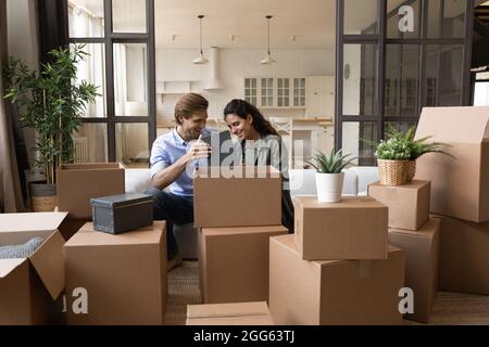 Glückliche junge Familie Paar Hausbesitzer Auspacken Habseligkeiten. Stockfoto