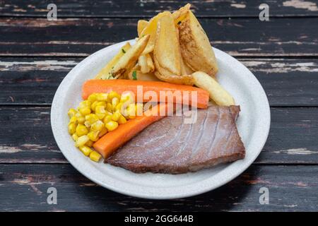 Konzeptionelles Gericht aus Schweinefleisch, Rindfleisch, Huhn. Mit Karotten und Mais garnieren. Nahaufnahme. Stockfoto