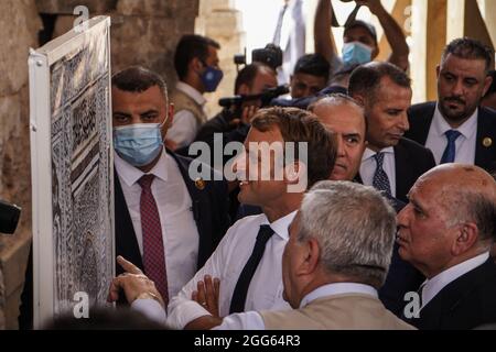 Mosul, Irak. August 2021. Der französische Präsident Emmanuel Macron besucht die al-Nuri-Moschee, in der 2014 das islamistische Staatenkalphat ausgerufen wurde. Die UNESCO rekonstruiert die aus dem 12. Jahrhundert erbaute Al-Nuri-Moschee und ihr Al-Hadba-Minarett, die 2017 während der Schlacht gegen den Islamischen Staat in Mosul beschädigt wurden, als Teil von drei Wiederaufbauprojekten, die von den Vereinigten Arabischen Emiraten finanziert wurden, um die Wahrzeichen der Altstadt von Mosul wiederherzustellen. Quelle: Ismael Adnan/dpa/Alamy Live News Stockfoto