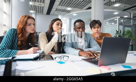 Eine vielfältige Gruppe von fokussierten multikulturellen Menschen, die PC im Büro nutzen Stockfoto