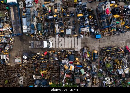 Eine Luftaufnahme mit Blick auf einen Schrottplatz mit Metallschrott und Fahrzeugen mit Kopierplatz Stockfoto