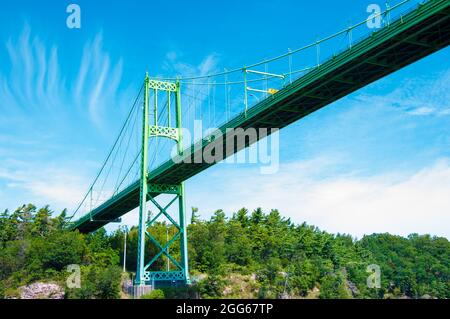 Ein schöner Blick auf die Thousand Islands Bridge über den St. Lawrence River über die dichte Vegetation Stockfoto