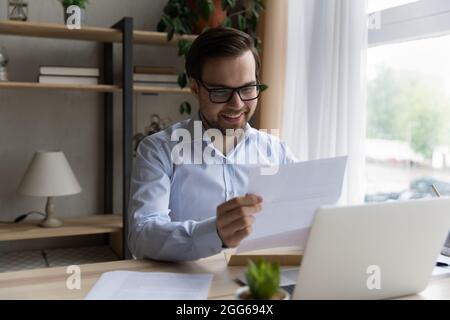 Glücklich aufgeregt Geschäftsmann Lesung erhielt Papierbrief Stockfoto