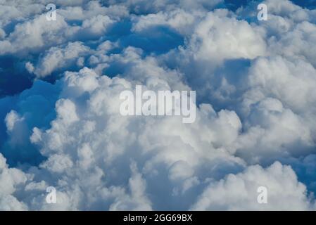 Blick auf den Himmel über den Wolken. Blauer Himmel hohe Ansicht aus Flugzeug-Fenster Wolken Formen. Himmel-Wolken Hintergrund Stockfoto