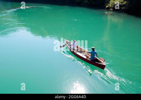 Luftaufnahme von Mutter und Sohn, die in einem roten Kanu auf dem Fluss Soca in der Nähe von Most na Soci, Avce, Slowenien, rudern Stockfoto