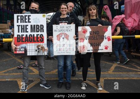 London, Großbritannien. August 2021. Tierrechtler aus Camp Beagle stehen mit Schildern vor dem Smithfield Fleischmarkt am Ende eines Nationalen Tierrechtsmarsches. Camp Beagle fordert die Freilassung von Beagle-Hunden, die für die Tierforschung von MBR Acres in Huntingdon aufgezogen wurden. Animal Rebellion, ein Ableger der Extinction Rebellion, organisierte den marsch zum sechsten Tag der Impossible Rebellion-Proteste von Extinction Rebellion in London. Kredit: Mark Kerrison/Alamy Live Nachrichten Stockfoto