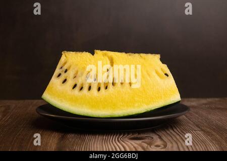 Gelbe Wassermelone auf schwarzem Teller, anders denken Stockfoto