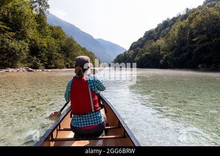 Frau rudert im Kanu auf dem Fluss Soca in der Nähe von Tolmin, Slowenien