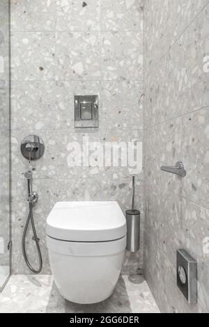 Modernes, minimalistisches Badezimmer mit Chrom-Accessoires im Badezimmer und grauen Fliesen Stockfoto