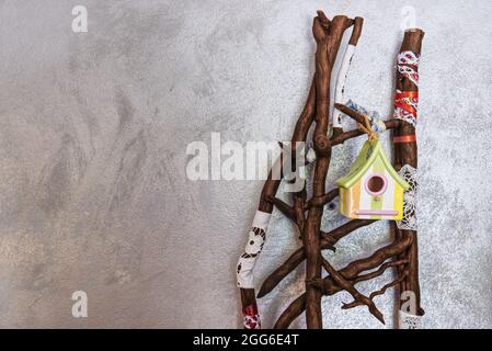 Eine Installation mit trockenen Ästen und Vogelhaus auf silbernem Hintergrund Stockfoto