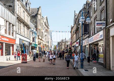 Shopper an einem Sommersamstag in der belebten Fußgängerzone High Street in Dunfermline, Fife, Schottland. Männer, Frauen und Kinder vor den Geschäften. Stockfoto