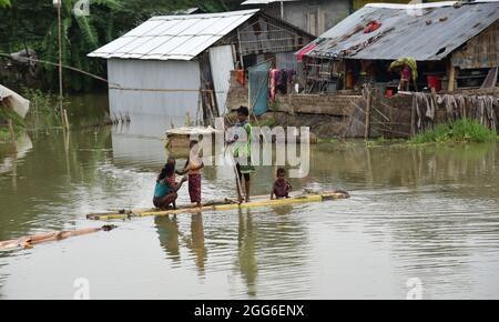 Guwahati, Guwahati, Indien. August 2021. Kinder nutzten ein Bananenfloß, um am Sonntag, dem 29. August 2021, in einem von Überschwemmungen betroffenen Dorf im Distrikt Morigaon in Assam Indien das Hochwasser zu überqueren.der Anstieg des Wasserpegels in verschiedenen Flüssen des Staates verursacht Überschwemmungen in fast 15 Distrikt von Assam und verursacht Schäden an den Kulturen (Bildnachweis: © Dasarath Deka/ZUMA-Pressdraht) Stockfoto