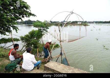 Guwahati, Guwahati, Indien. August 2021. Am Sonntag, dem 29. August 2021, verbreitete ein Mann ein Fangnetz, um Fische im Hochwasser in einem von Überschwemmungen betroffenen Dorf im Distrikt Morigaon in Assam Indien zu fangen.der Anstieg des Wasserstials verschiedener Flüsse des Staates verursacht eine Überschwemmung in fast 15 Distrikt von Assam, die Ernteschäden verursacht (Bildnachweis: © Dasarath Deka/ZUMA-Pressdraht) Stockfoto