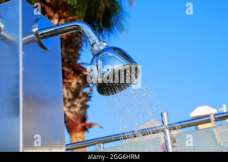 Nahaufnahme des Duschkopfes im Freien. Außenpooldusche. Wasser läuft vom Duschregner am Pool Stockfoto