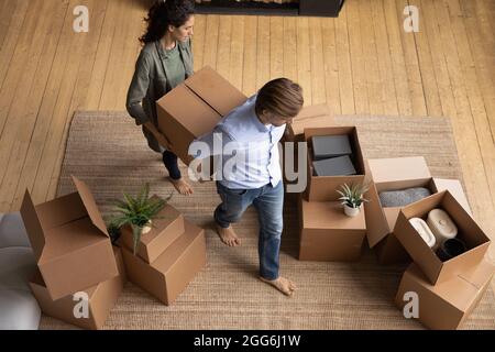 Glückliches junges Familienpaar bewegt Sachen in neue Wohnung. Stockfoto