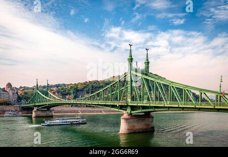 Τhe Freiheitsbrücke (oder Freiheitsbrücke) in Budapest, Ungarn, die Buda und Pest über die Donau verbindet. Der Gellért-Hügel ist im Hintergrund. Stockfoto