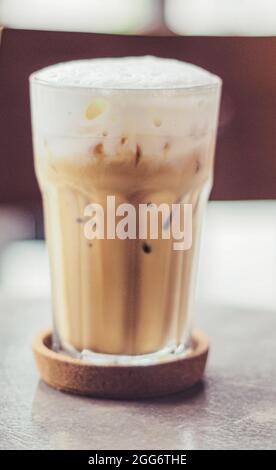 Eiskaffee in einem klaren, hohen Glas mit Milch oder Rahm darauf Stockfoto
