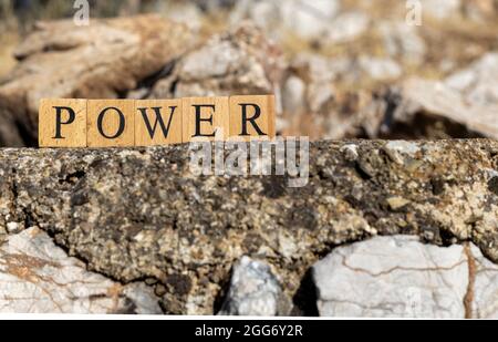 Das Wort der Macht wurde aus Holzwürfeln erschaffen. Fotografiert an der Wand. Nahaufnahme. Stockfoto