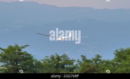 Thiene, Italien 8. JULI 2021 Segelflugzeug im Flug in sehr niedriger Höhe direkt über den Baumwipfeln. Schempp-Hirth Duo Discus Stockfoto