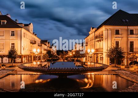 Brunnen in Frantiskovy Lazne bei Sonnenuntergang, Tschechische Republik.schöne Kurstadt in Westböhmen, Thermalgebäude mit typischer gelber Fassade Stockfoto