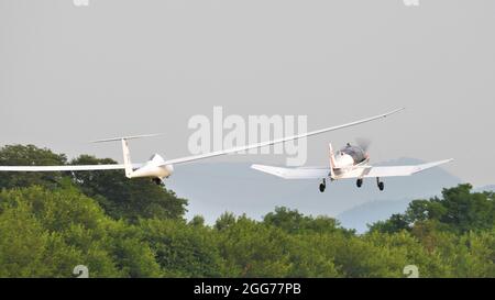 Thiene, Italien 8. JULI 2021 Propellerflugzeug, das einen Segelflugzeug im Flug schleppt. Schempp-Hirth Duo Discus Stockfoto