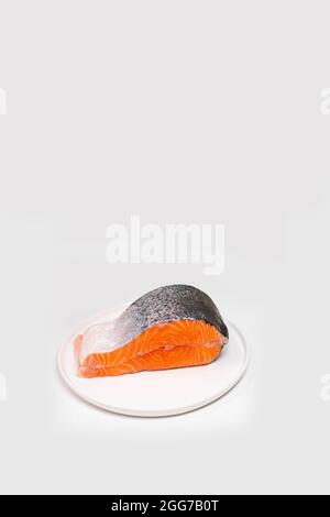 Einzelnes Steak mit frischem rohem Lachsfisch auf weißem Hintergrund. Kreatives, minimalistisches Layout aus Fisch mit Platz für Kopien Stockfoto